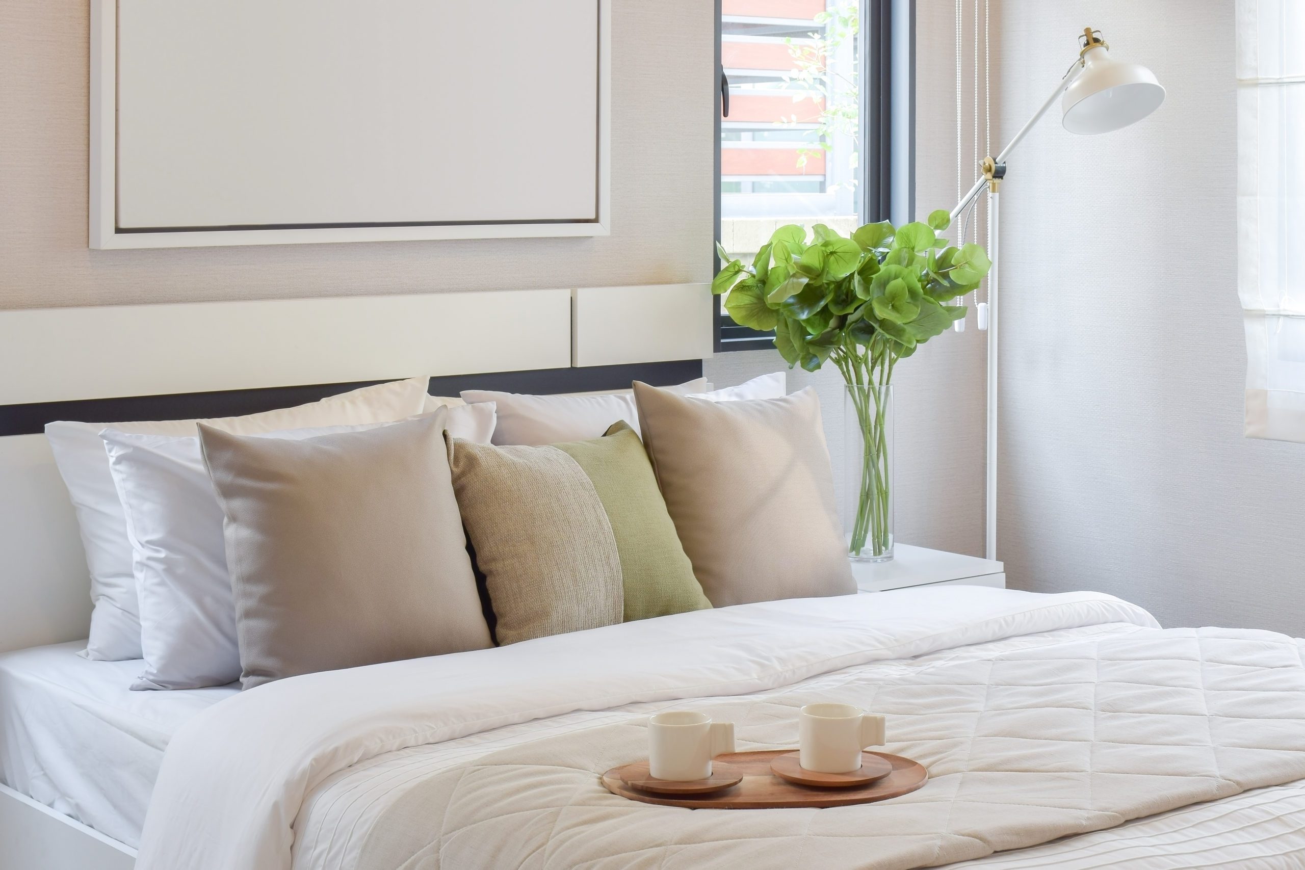 wooden tray of tea set on bed in modern bedroom interior